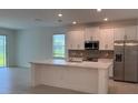 Modern kitchen with stainless steel appliances, white cabinets, and a large island at 2560 Cavanaugh Dr, Orlando, FL 32817