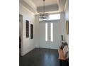 Modern entryway with dark hardwood floors, a bench, and a stylish light fixture at 816 Johns Point Dr, Oakland, FL 34787