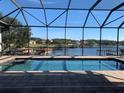 A luxurious pool is surrounded by a screened enclosure offering stunning lake views at 816 Johns Point Dr, Oakland, FL 34787