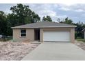 Charming single-story home with a neutral-colored exterior and a two-car garage on a sunny day at 1608 Jefferson Dr, Mount Dora, FL 32757