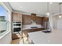 Modern kitchen with stainless steel appliances, a center island with quartz countertops, and stylish pendant lighting at 1694 Pinecliff Dr, Apopka, FL 32703