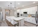 Modern kitchen featuring white cabinetry, an island with bar seating, stainless steel appliances, and stylish backsplash at 1685 Andover Ridge Dr, Deland, FL 32720