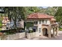 Two-story home features a red tile roof, porte cochere, and beautiful green vine wall accent at 732 Edgewater Dr, Orlando, FL 32804