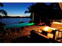 Evening shot of the outdoor living space with fire pit and lakeside illuminated pool at 1010 Strathmore Dr, Orlando, FL 32806