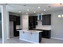 Modern kitchen with dark cabinetry, stainless steel appliances, an island, and tiled floors at 1181 Basalt Ln, Sanford, FL 32771