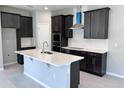 Bright kitchen featuring a center island, dark cabinets, stainless appliances, and light countertops at 1181 Basalt Ln, Sanford, FL 32771