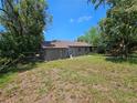 Back exterior view of the house with a large backyard at 3408 Lewis Ct, Orlando, FL 32805