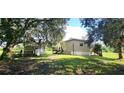 View of the backyard featuring an outbuilding, shaded by large trees at 2661 Waccassa St, Geneva, FL 32732