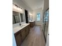 Modern bathroom featuring double vanities, sleek mirrors, and wood-look tile flooring at 282 Kimble Ave, Oviedo, FL 32765