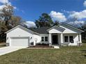 Beautiful single-story white home with a two-car garage and well-kept lawn with a blue sky backdrop at 292 Kimble Ave, Oviedo, FL 32765