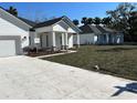 Modern exterior featuring white siding, black roof, and well-manicured landscaping and driveways at 292 Kimble Ave, Oviedo, FL 32765
