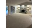 Spacious living room with a stone fireplace, built-in shelving, and sliding door access to outdoor area at 3336 Edgecliffe Dr, Orlando, FL 32806