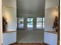 Open living room with neutral tones, sliding glass doors to the pool, and decorative flowers at 3336 Edgecliffe Dr, Orlando, FL 32806
