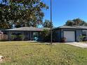 Newly painted home with a spacious lawn and a flagpole at 1713 Longleaf Dr, Saint Cloud, FL 34769