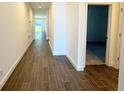 Well-lit hallway featuring modern wood flooring and neutral walls, leading to various rooms in the house at 14771 Erice Ave, Clermont, FL 34714
