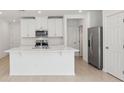 Modern kitchen island featuring a sink, breakfast bar, and sleek white countertops at 4316 Ranch House Rd, Saint Cloud, FL 34772