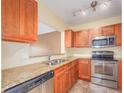 Well-lit kitchen with stainless steel appliances, granite counters, and wooden cabinets at 2246 Stonington Ave # 2246, Orlando, FL 32817