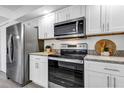 Modern kitchen featuring stainless steel appliances, granite countertops, and white cabinetry at 1150 Carmel Cir # 201, Casselberry, FL 32707