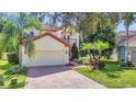 Two-story house with a red tile roof, attached garage, and beautiful landscaping at 8168 Via Bella Notte, Orlando, FL 32836