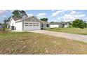 Spacious two-car garage with an extra-long driveway and a well-maintained lawn at 3186 Mapleshade St, Deltona, FL 32738