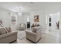 Spacious living room with beige sofas and a view into the kitchen at 720 Split Hoof Dr, Saint Cloud, FL 34771