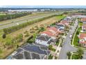 An aerial view of a residential area, nestled next to lush greenery and a serene lake at 8325 Topsail Pl, Winter Garden, FL 34787