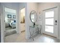 Inviting foyer featuring a modern glass table, and views to the bedroom and bathroom at 2709 Scrapbook St, Kissimmee, FL 34746