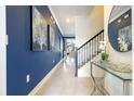 Hallway with staircase, stylish runner, large wall art, and view of living area at 2709 Scrapbook St, Kissimmee, FL 34746