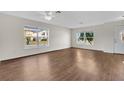 Spacious living room with wood-look flooring, a ceiling fan, and abundant natural light at 1103 Epson Oaks Way, Orlando, FL 32837