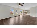Open-concept living space with wood-look floors, ceiling fan, and sliding glass door to the backyard at 1103 Epson Oaks Way, Orlando, FL 32837