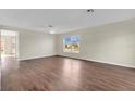 An open living space with sleek floors, a ceiling fan, and bright natural light at 1103 Epson Oaks Way, Orlando, FL 32837