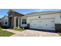Attached two-car garage with brick paver driveway and professionally landscaped front yard at 329 Lady Palm St, Apopka, FL 32703