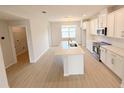 Spacious kitchen with white cabinetry, stainless steel appliances, and a central island flowing into the living spaces at 791 Pilea St, Apopka, FL 32703