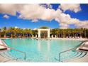 A large community pool with waterfall feature, palm trees, and blue sky offers a resort-like feel at 2621 Calistoga Ave, Kissimmee, FL 34741