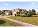 House exterior with a driveway, landscaping, and American flag at 8162 Lazy Bear Ln, Winter Park, FL 32792