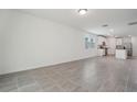 Open concept living room with grey tile floors and kitchen at 5186 Minneola Ln, Saint Cloud, FL 34772