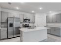 Modern kitchen with gray cabinets, stainless steel appliances, and an island at 424 Wayland Dr, Haines City, FL 33844