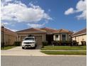 Charming single-story home with a well-manicured lawn and a tile roof, featuring a car parked in the driveway at 3047 Sangria St, Kissimmee, FL 34744