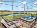 Screened-in patio with lounge chairs offering scenic views of the lake and a relaxing hot tub at 8938 Cabot Cliffs Dr, Davenport, FL 33896