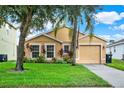Beautiful home with manicured lawn and garden, complemented by mature trees at 188 Ridgemont Ct, Davenport, FL 33896