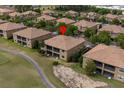 Aerial view of a brown-roofed home in a community with lush green landscaping at 8930 Azalea Sands Ln, Davenport, FL 33896