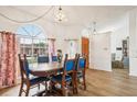 Bright dining room featuring wood floors, a large window, and seating for six at 1546 Thornhill Cir, Oviedo, FL 32765