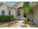 Close up of a front entrance with beautiful landscaping and an arched entryway at 2657 Queen Mary Pl, Maitland, FL 32751