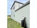Side view showcasing light gray siding and a water softener system at 291 Whistling Duck Trl, St Cloud, FL 34771