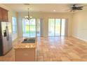 Open kitchen and living area with tile floors and sliding doors to patio at 7465 Excitement Dr, Reunion, FL 34747