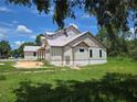 New construction home featuring a modern elevation, large windows, and situated on a large lot at 405 Long And Winding Rd, Howey In The Hills, FL 34737