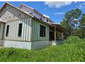 New construction home featuring a modern elevation, large windows, and a covered back porch at 405 Long And Winding Rd, Howey In The Hills, FL 34737