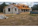 New construction home with block construction and a dumpster on the property at 405 Long And Winding Rd, Howey In The Hills, FL 34737