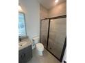 Modern bathroom featuring gray vanity and sleek walk-in shower with black trim at 2110 Whitney Marsh Aly, Orlando, FL 32804