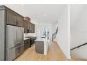 Modern kitchen with stainless steel appliances, island, wood floors, and stylish cabinets at 2110 Whitney Marsh Aly, Orlando, FL 32804